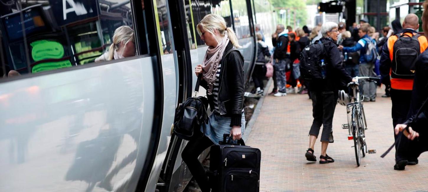 Togstation med tog og passagerer